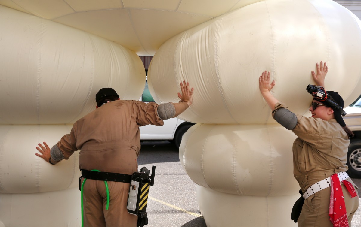 Chris Sizemore, left, and Veronica Victor, right, hold up the legs of a giant inflated Stay Puff Marshmallow Man that was a part of their fundraising strategy Saturday at the Point Pleasant, W. Va, Mothman Festival. The two are a part of the Ghost Busters West Virginia Division that was raising money for a toy drive for the Childrens Home Society of West Virginia. (Jennifer Coombes)