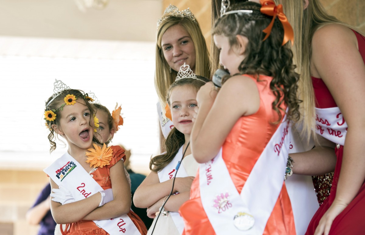 Nelsonville’s Little Miss Parade of The Hills 2nd Runner-up Ruby Copus reacts to something Little Miss Dannilyn Rutter is saying during The Plains 2015 Indian Mounds Festival in The Plains, Ohio on Sunday, October 4, 2015. (Margaret Sabec/WOUB)