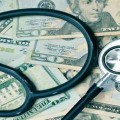 A graphic has a stethoscope on money. It is trying to depict health insurance.