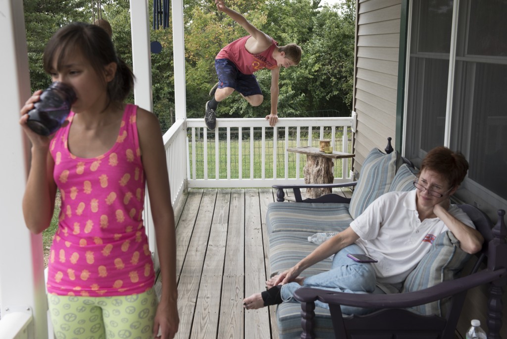 Gave jumps onto the porch as Olivia, 13, and Annette, the family's babysitter, relax.