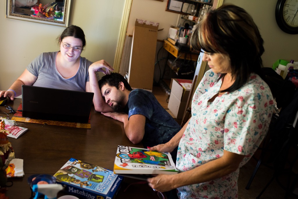 Nurse Barbie Williams, right, pulls out a board game with play with Bubba and his stepsister Leah Barley, left.