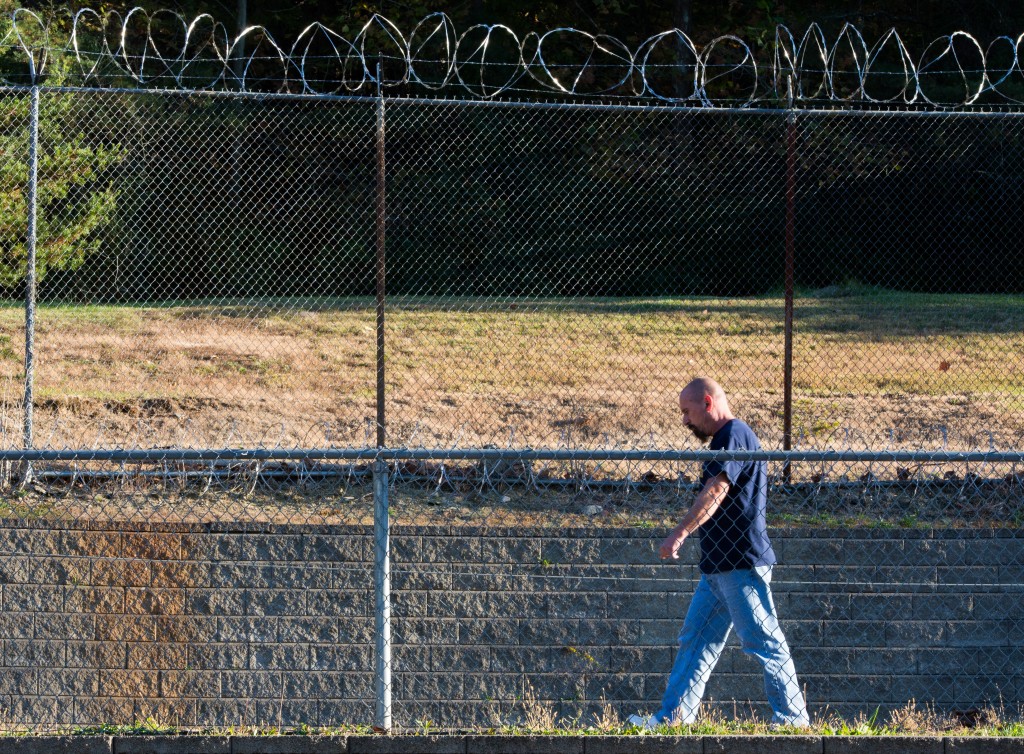 Duey walks along the barbed-wire fence in the recreational yard in the SEPTA Correctional Facility.