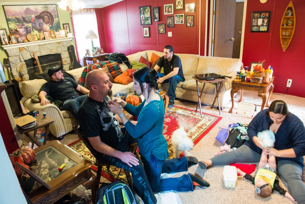Chelsea Puckett, Michele’s daughter, trims Duey’s goatee in the living room as Tiffany Francis changes the diaper of Nevaeh, her 6-month-old niece, and while Tim Puckett, left, talks with Tony Barley, Duey’s youngest brother.