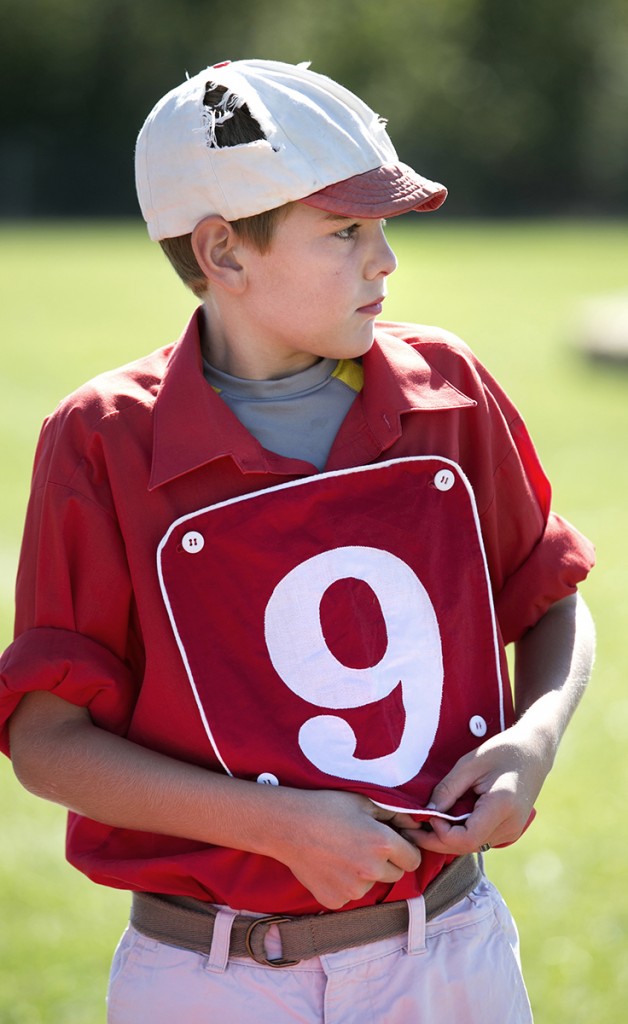 Isaiah Goebel, 11, tucks in his shirt and buttons on his front patch so that he can work the Ohio Cup as the Hamilton Blackbottom 9’s batboy Saturday in Columbus at the Ohio Cup. (WOUB/Jennifer Coombes)