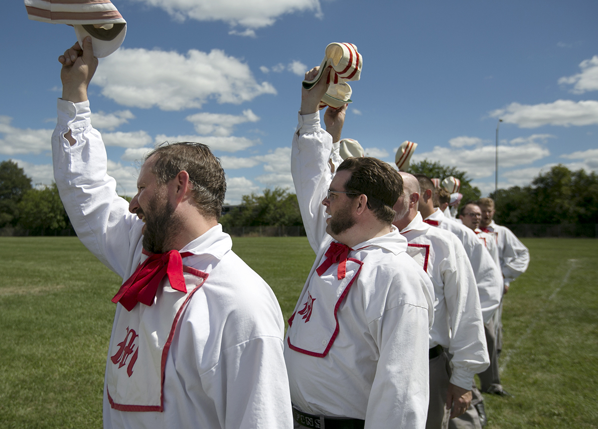 Sean “Musket” Harshbarger, left, and Dennis “Slow and Cautious” Kelley raise their hats and yell “Huzzah” at the end of a vintage baseball game Saturday in Columbus at the Ohio Cup. (WOUB/Jennifer Coombes)