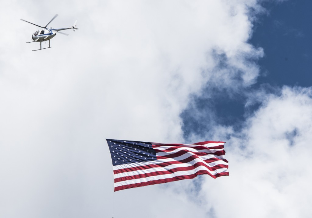 A flag is flown over the sternwheel boats by helicopter right before the start of the 2016 Sternwheel Festival Race. (Robert McGraw/WOUB)