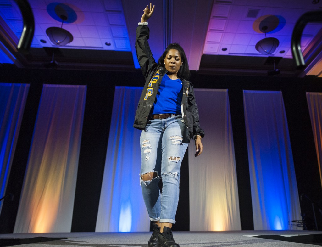 A student walks off stage holding up the symbol for her sorority at the Black Alumni Reunion Talent Show in the Baker Ballroom at Ohio University on September 17, 2016. (MICHAEL SWENSEN/WOUB)