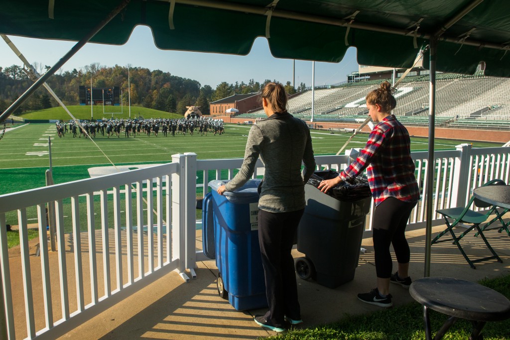 Melina Luise and Morgyn Freeland, recycling and zero waste personnel and students at Ohio University set up the bins for the GameDay Recycling Challenge at Peden Stadium on Saturday, October 15, 2016 in Athens, Ohio. (Jorge Castillo Castro/WOUB)