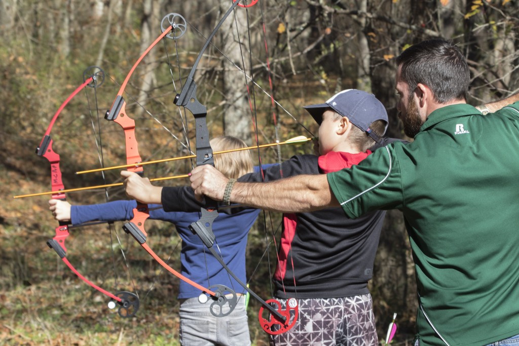 Chad Gatt, from the Raccoon Creek Partnership, advice Zach Mullins, attendee to the event, how to correctly hold the bow at the Raccoon Creek Partnership Archery Day Camp on Saturday, November 5, 2016, at Waterloo Aquatic Education Center, New Marshfield, Ohio. (Jorge Castillo Castro/WOUB)