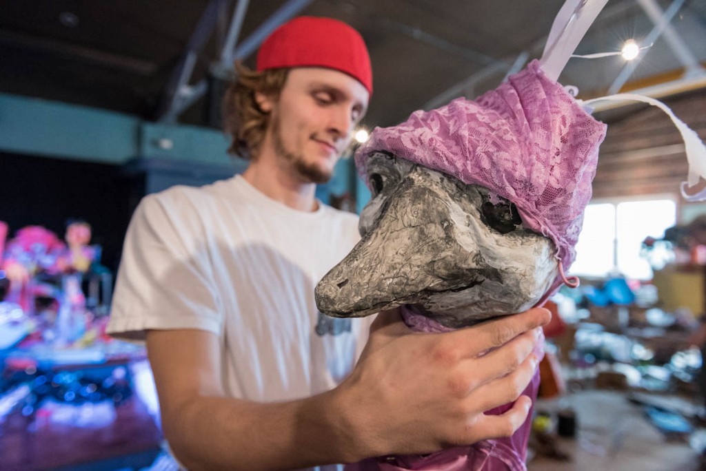 Cory Boggs, of Oak Hill, Ohio and an Ohio University senior studying art and psychology, puts the finishing touches on the puppet he created for the Honey for the Heart parade. (Photo by Atish Baidya)