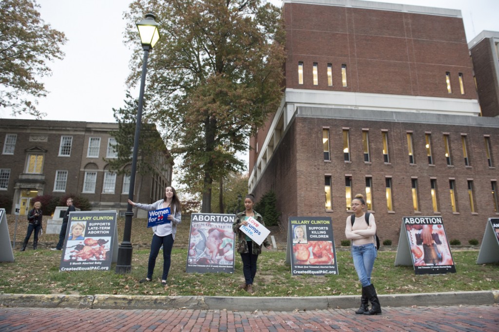 Members of Ohio University’s College Democrats try to deflect the message of the abortion signs put out by the Bobcats for Life organization on November 8, 2016. (Robert McGraw/WOUB)
