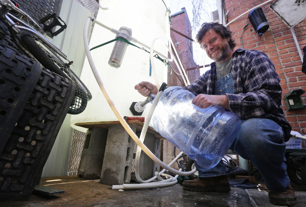 The 2014 toxic chemical spill in Charleston, West Virginia affected the water supply for more than 300,000 West Virginians and shut down schools, businesses and local governments. In this photo, Jonathan Steele, owner of Bluegrass Kitchen, fills a jug with water behind his restaurant. Steele installed a large tank in the back of his restaurant and was able to reopen using bottled water. (AP Photo/Steve Helber)