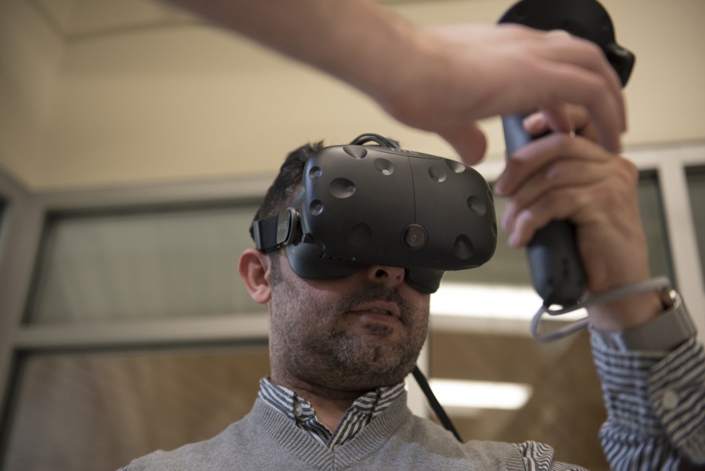 PhD student in instructional technology Mohammed A is shown how to use virtual reality equipment by Doctoral student in instructional technology Jeff Kuhn during the open house after the ribbon cutting ceremony of McCracken Hall on January 27, 2017. (Robert McGraw/WOUB)