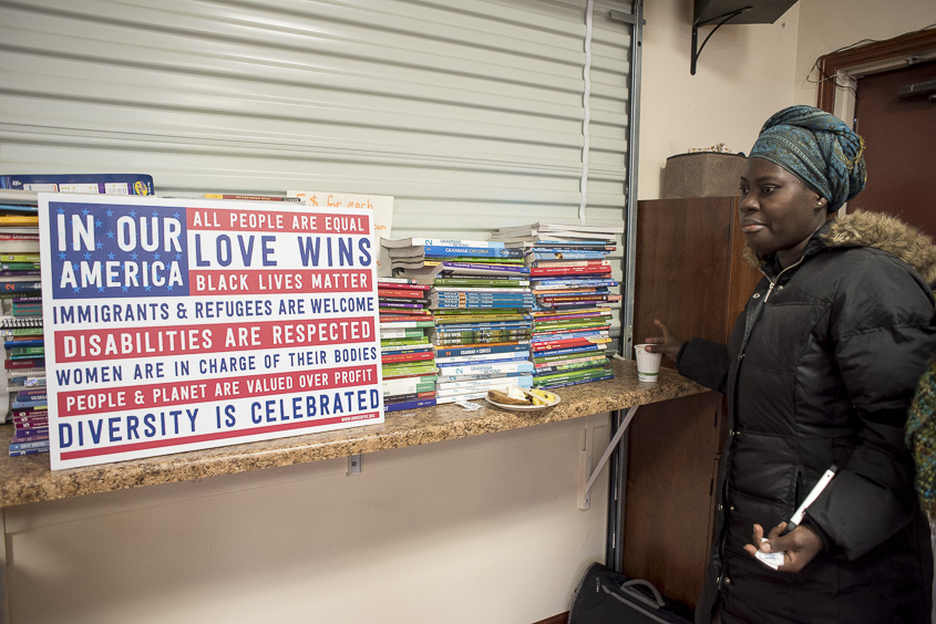 Shakirat Adetomiwa, a first year graduate student studying Public Health and African Studies, walks by a sign supporting diversity displayed at Ohio University's Islamic Center on January 20, 2017. (Camille Fine/WOUB)