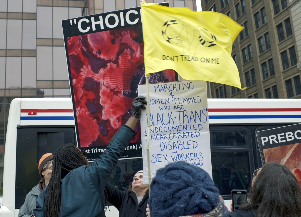 Pro-life protesters verbally spar with rally participants that are pro-choice, and marching for the rights of women, femmes, black and trans, undocumented, incarcerated, disabled, and sex workers at the otherwise peaceful WMW Ohio Sister March in Columbus, Ohio on January 15, 2017. (Margo Sabec/WOUB)