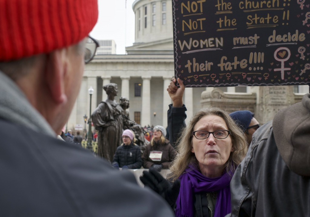 A pro-life protester, left, taunts pro-choice rally participants with a ÒchoiceÓ banner, and verbally spars with rally participants at the otherwise peaceful WMW Ohio Sister March in Columbus, Ohio on January 15, 2017. (Margo Sabec/WOUB)