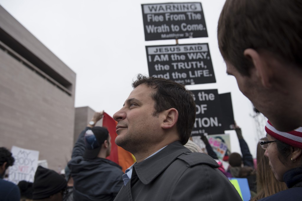 Virginia House of Delegates member, Mark Levine, stands in front of a protester on Saturday morning, January 21, 2017, surrounded by hundreds of thousands of participate at the Women’s March on Washington. (Margo Sabec/WOUB)