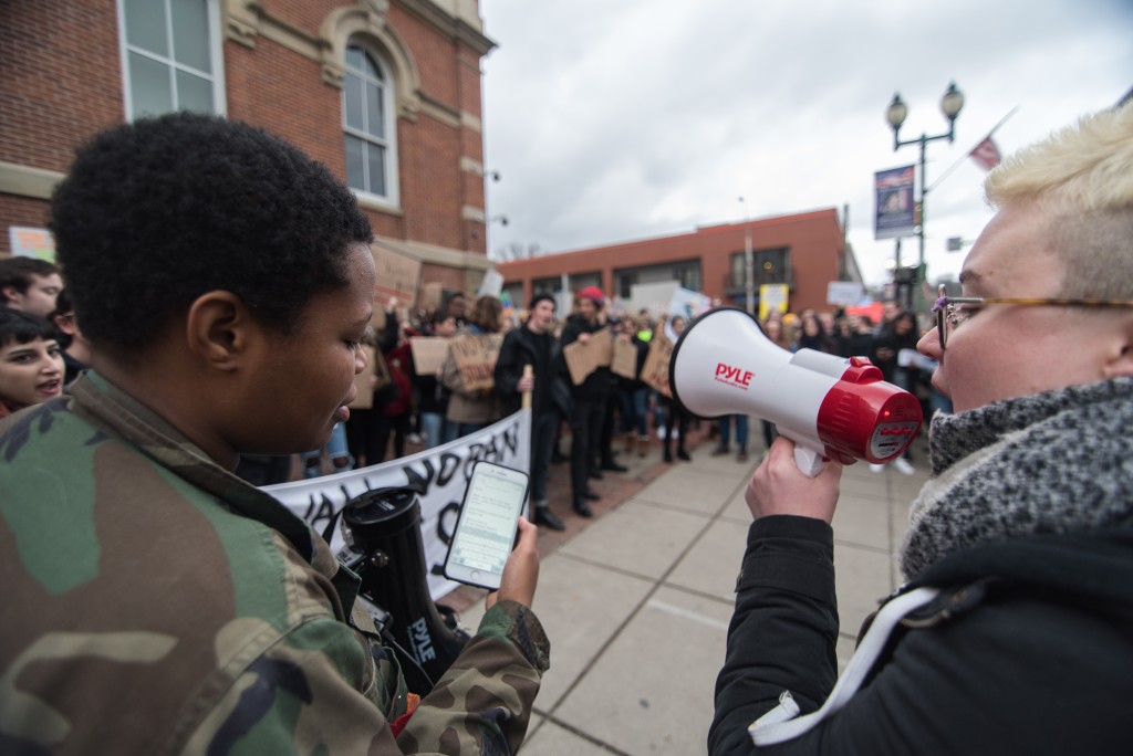 Anissa Matthews and Rachel Lewis shout chants to the crowd of protesters in front of the Athens County Courthouse on Wednesday, February 1, 2017. (Nickolas Oatley/WOUB)