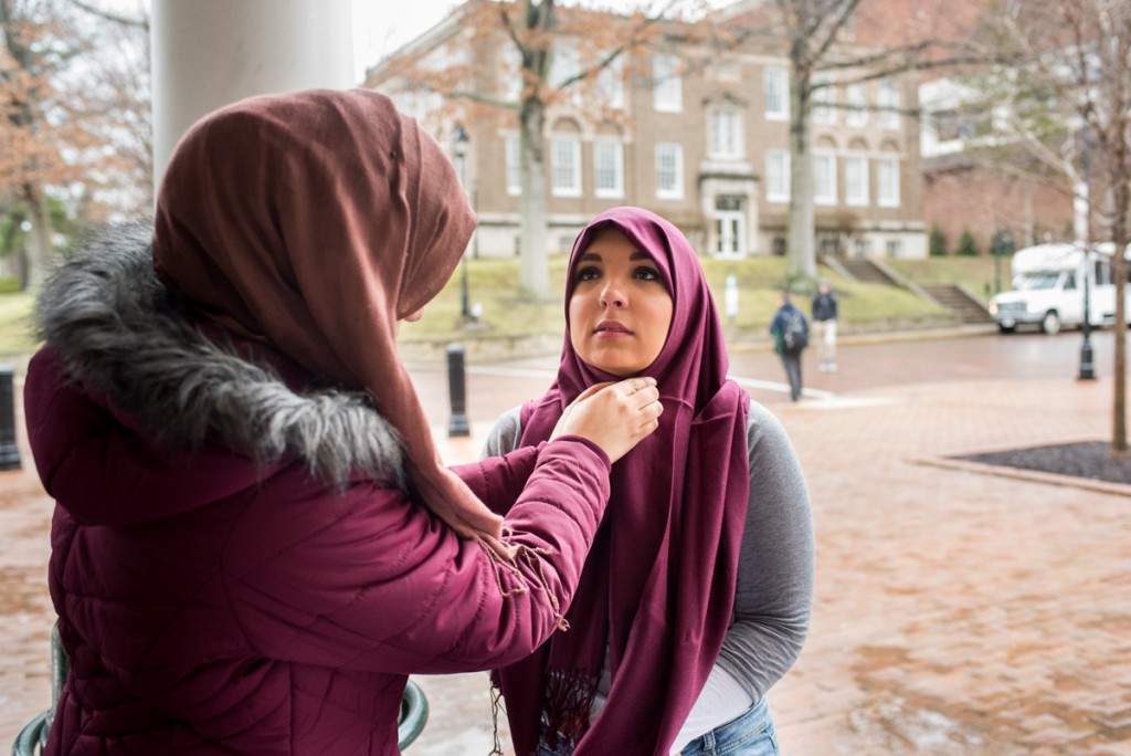 Reem Al-khalqi adjusting Ohio University student, Nancy Mitchell, hijab after she put it on for World Hijab Day at Ohio University, in Athens, Ohio on February 1, 2017. (Carolyn Rogers/WOUB)