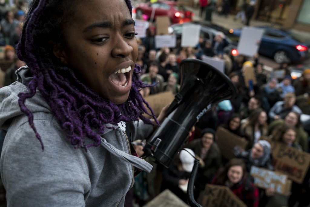 Jolana Watson, a student at Ohio University, begins a chant during a protest held at the Athens Courthouse on February 1, 2017. (Michael Swensen/WOUB)