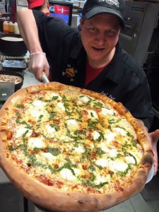 Avalanche Pizza managing member pose with a fresh pie. (Facebook.com/avalanchepizza)
