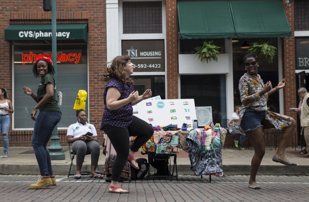 Jolana Watson of Maryland, left, Brianna Sheridan of Cleveland, Ohio, and Becky Salami of South Carolina, right, dances on the International Week Street Fair on the Court Street in Athens, Ohio, on April. 15, 2017. (Wangyuxuan Xu/WOUB)