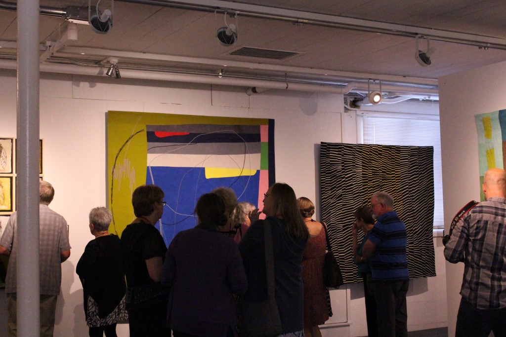 People admire the works selected for the 2017 Quilt National exhibition on May 26, 2017. (WOUB/Emily Votaw)