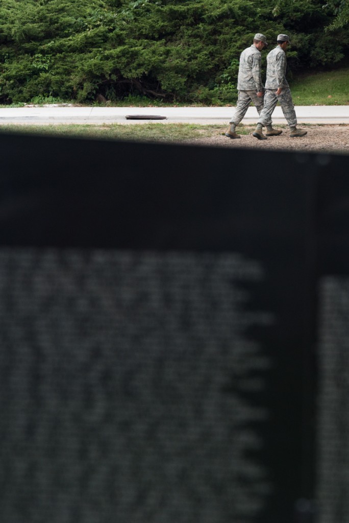 Two U.S. Army soldiers walk behind the Vietnam Veterans Memorial. (Nickolas Oatley/WOUB)
