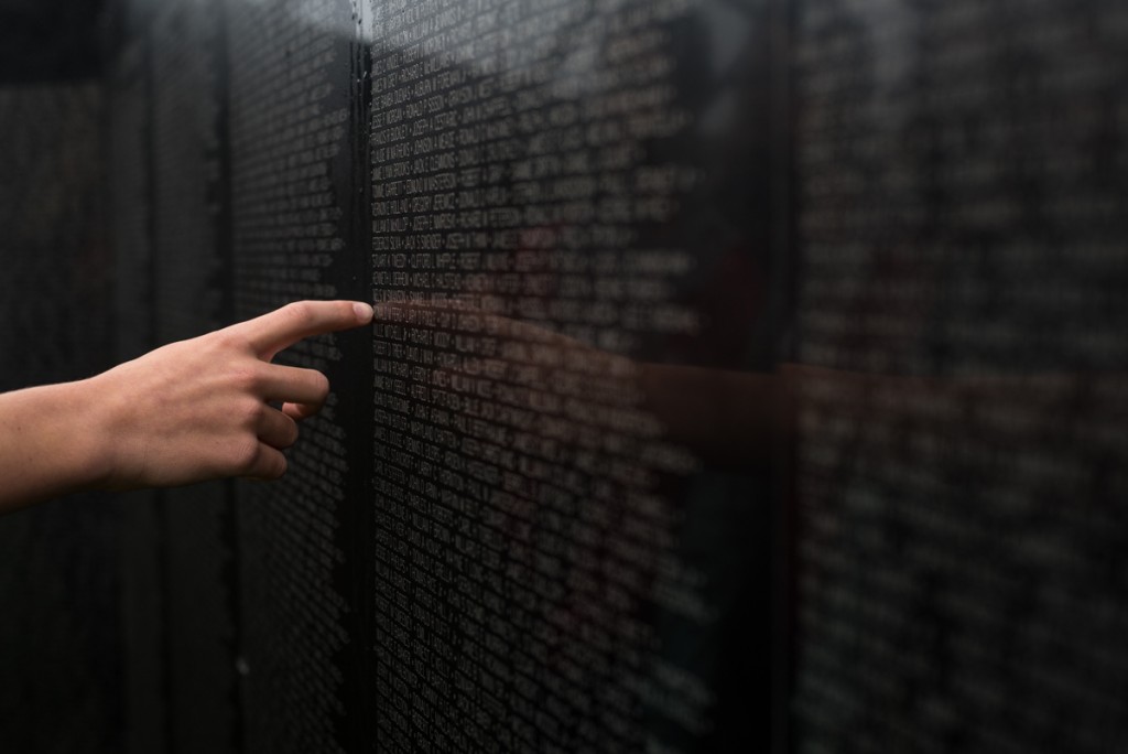 A student from Crooksville Elementary touches a name on "The Wall That Heals". (Nickolas Oatley/WOUB)
