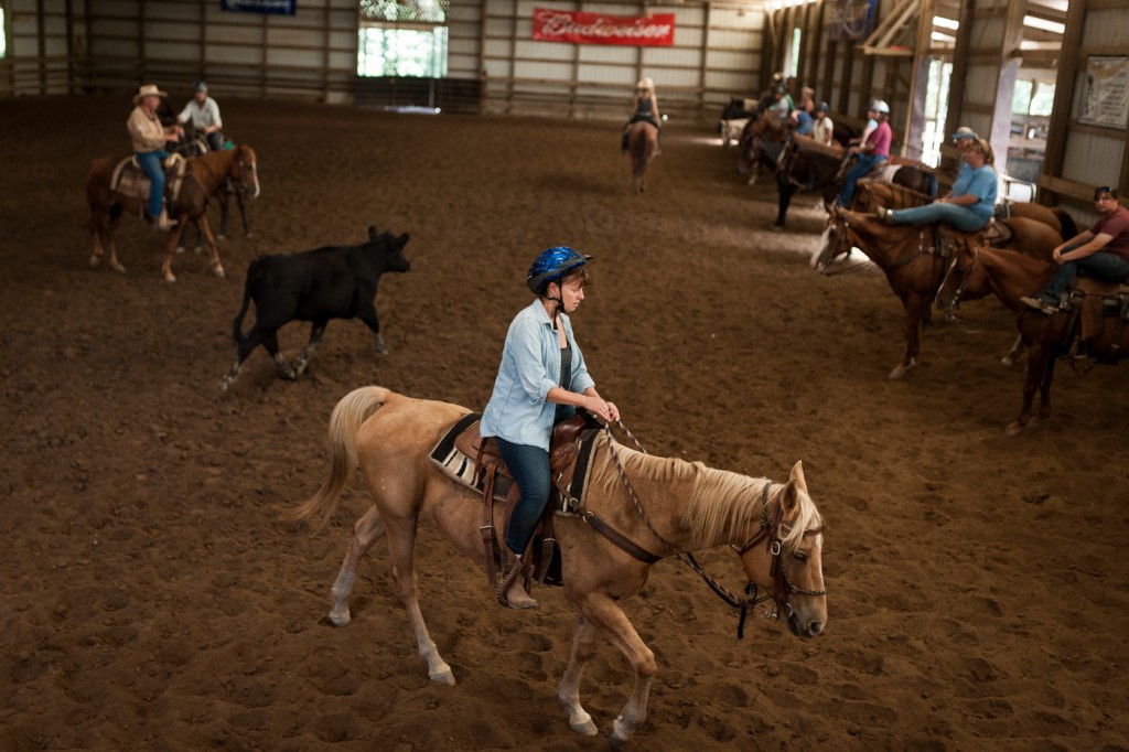 A cowgirl jumps back in line after learning to herd a cow. (Michael Swensen/WOUB)