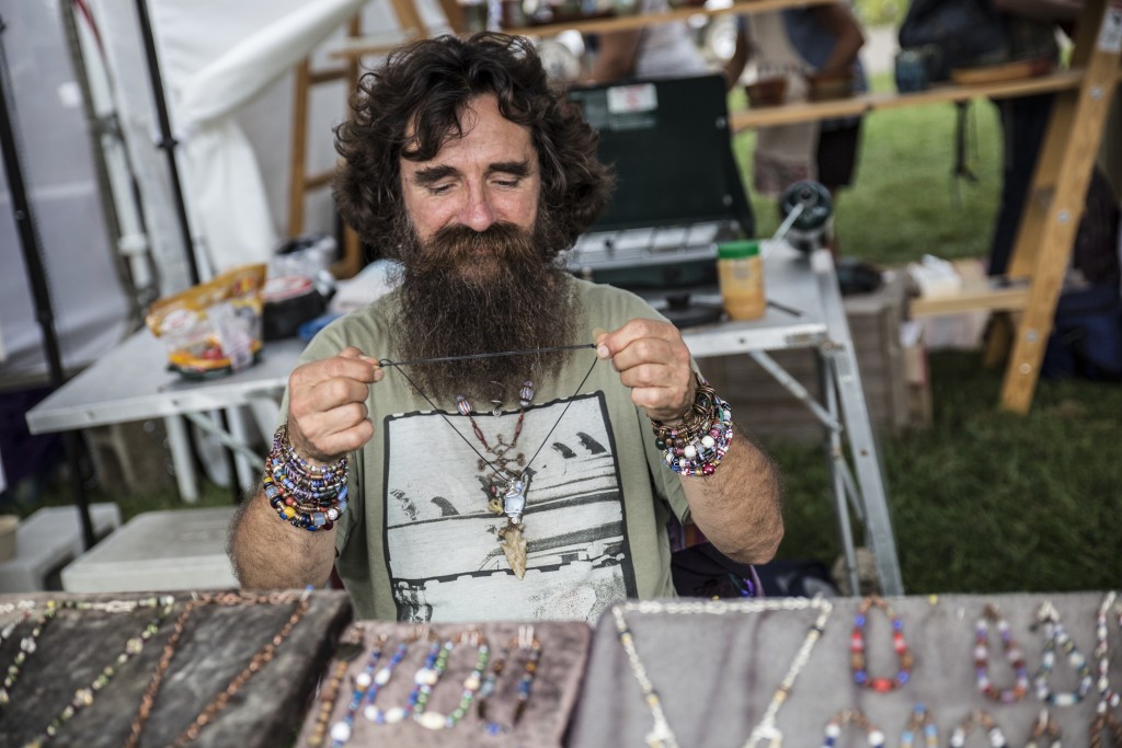 Rob Kola, a local jeweller, laces his handmade necklace in Pawpaw Festival in Albany, Ohio on Sep. 16, 2017. (Wangyuxuan Xu/WOUB)