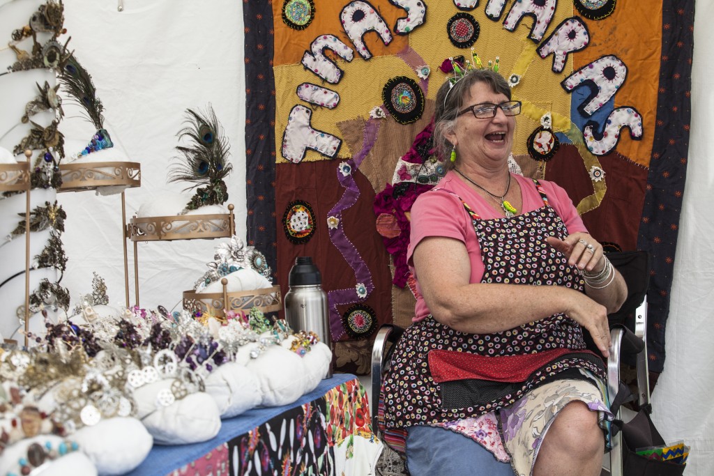 Tina Kelsay, a local artist , chats with her firend in front of  her handmade crown stall in Paw Paw Festival in Albany, Ohio on Sep.16, 2017.(Wangyuxuan Xu/WOUB)
