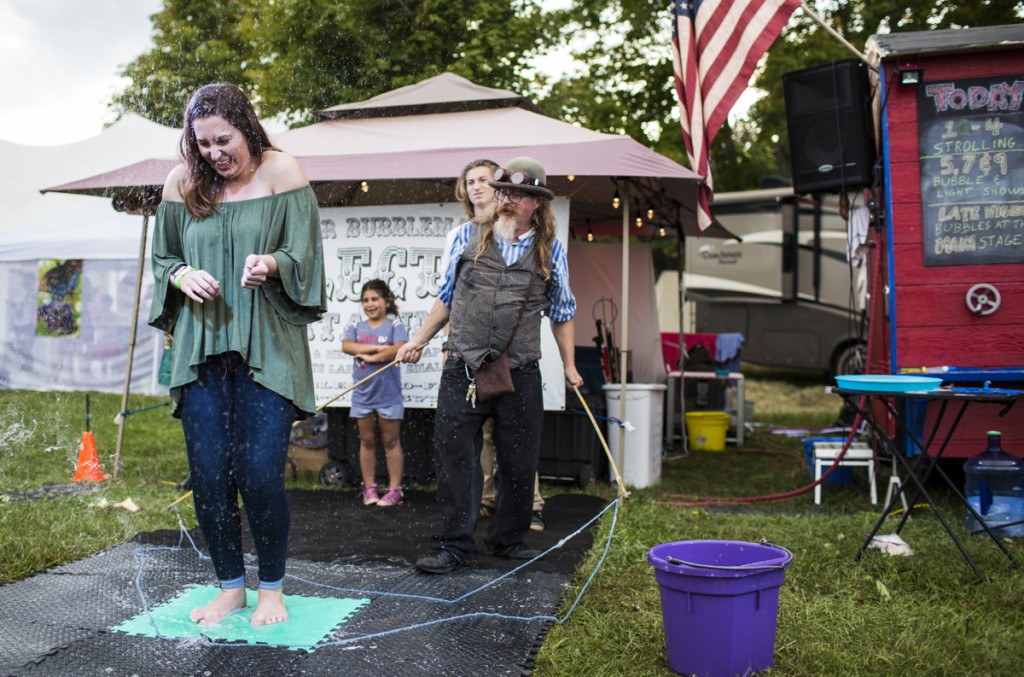 Ally Bucher reacts under a popped bubble created by Professor Bubblemaker at The Pawpaw Festival on Saturday, September 16, 2017. (Erin Clark/WOUB)