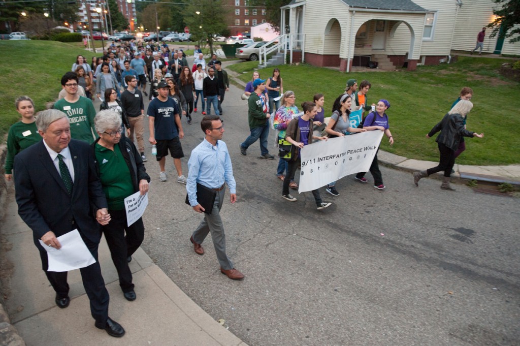 Participants in the Interfaith Peace Walk round the final corner before arriving at the Islamic Center of Athens, accompanied by President Duane Nellis (left) and his wife Ruthie Nellis. (Drake S. Withers / WOUB)