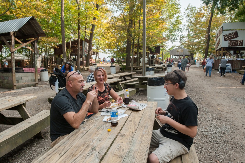 Scott Coulombe (left), Beverly Hetzel, and Gavin Colombe, from St. Louisville, Ohio, share a meal at the Backwoods Fest in Thornville, Ohio.