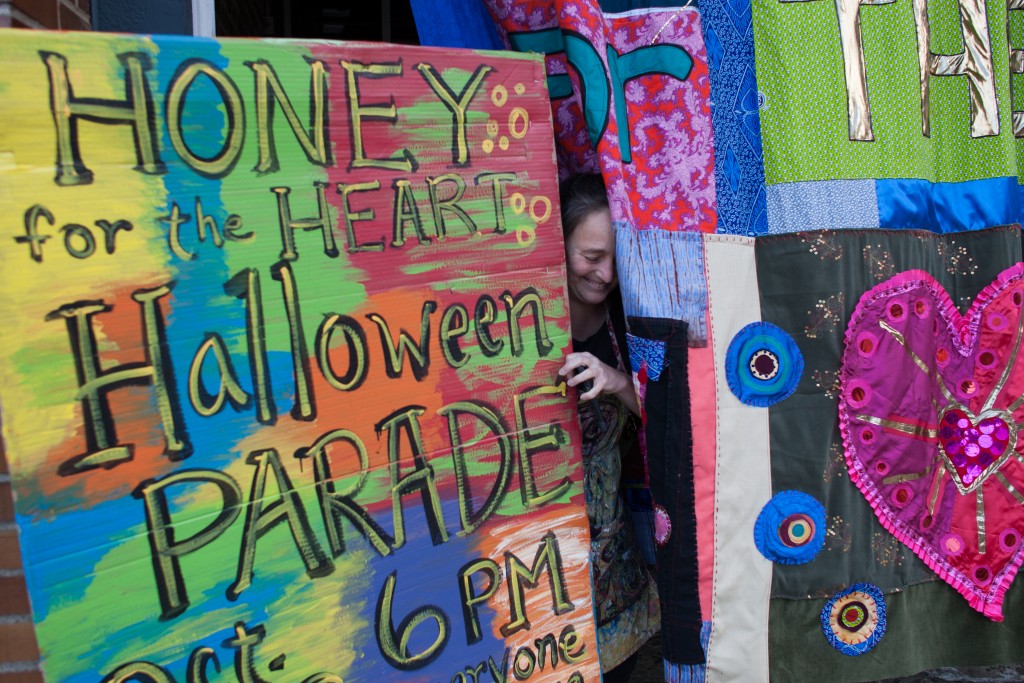 Patty Mitchell squeezes by a parade advertisement and a handmade quilt outside of Central Venue in Athens, Ohio, on October 24, 2017.   (Michael Johnson/WOUB)