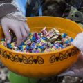 Kid grabs candy from Cathy Baker while saying "Trick-or-treat" in Athens, Ohio on Oct, 26, 2017.