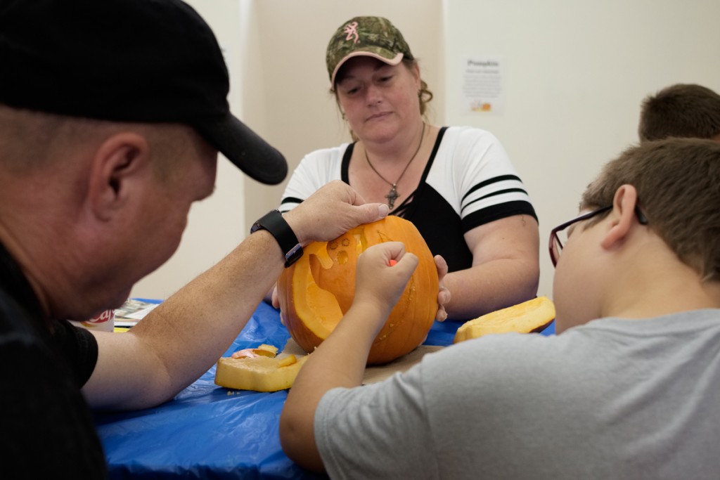 Lycan Cline, 8, carves a pumpkin with his father, Jeff Cline, and his mother, Felicity Kessler at Pumpkin Fest in Athens, Ohio, on October 21, 2017. (Drake Withers / WOUB)