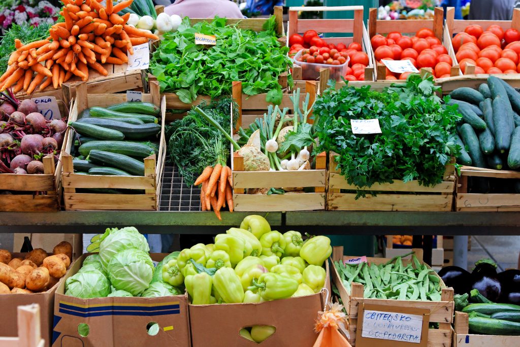 Fruits and vegetables on display at a farmer's market stall.