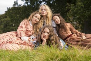 Cast of Little Woman laying in grass, including Willa Fitzgerald as Meg, Kathryn Newton as Amy, Annes Elwy as Beth and Maya Hawke as Jo