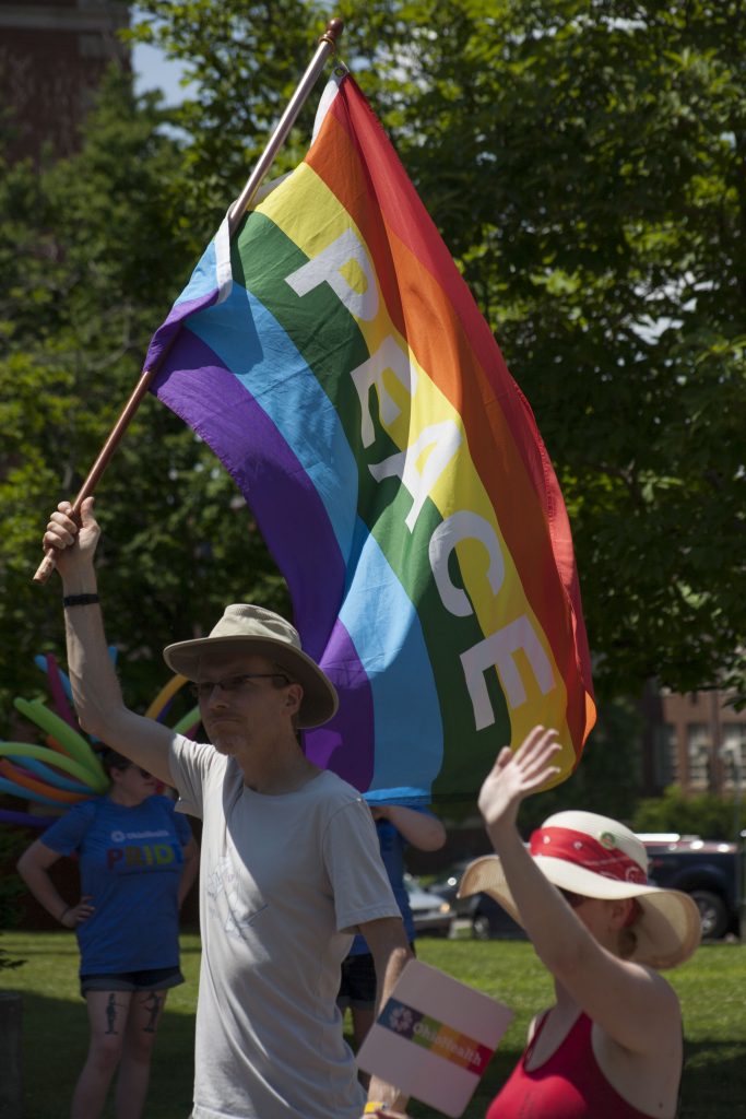 A parade participant waves a rainbow flag that says "Peace" during the Athens Pride Parade in 2018.