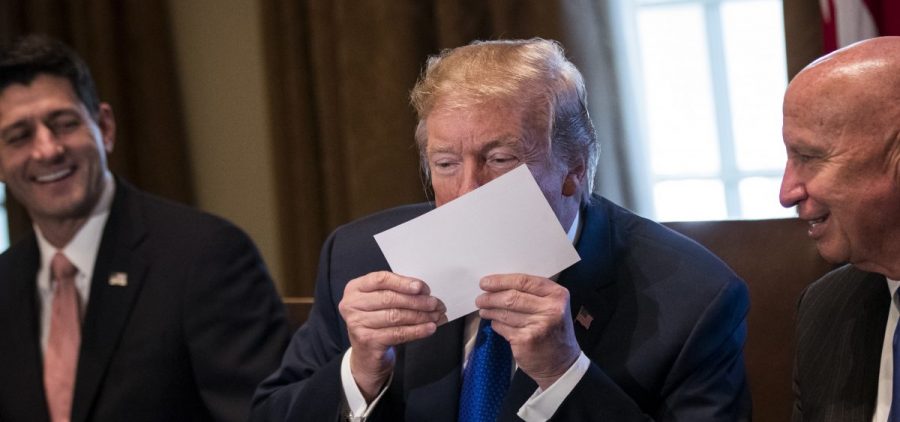 President Trump kisses a mock-up of a 1040 "postcard" during a meeting with GOP congressional leaders.
