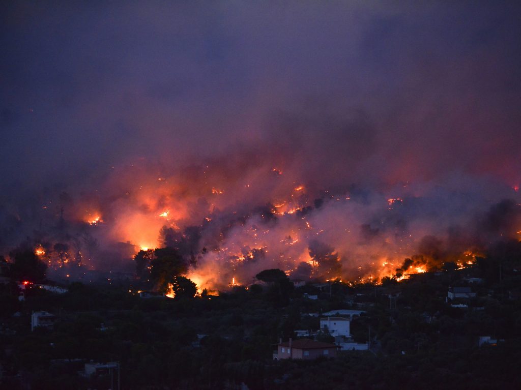 Flames rise as a wildfire burns in the town of Rafina, near Athens, on July 23, 2018.
