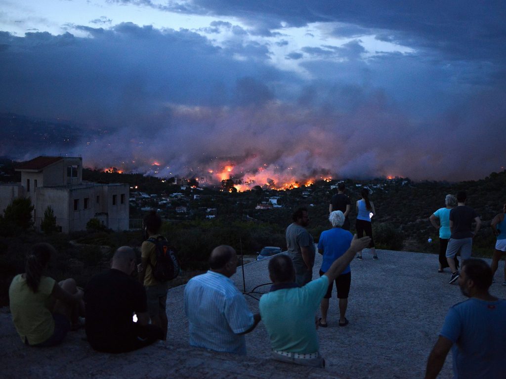 People watch a wildfire in the town of Rafina, near Athens, on July 23, 2018.