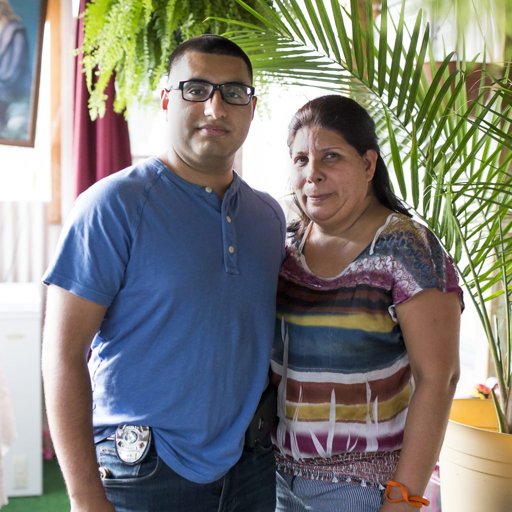 Officer Eduardo Mata, left, stands with his mother Leticia Mata, right, on the porch of the trailer they share in Galax, Va. Mata graduated from the police academy on June 28. He is one of only two Spanish-speaking officers. Mata grew up in the Hispanic community in Galax and says that many residents were afraid of encounters with police.