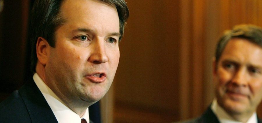 Brett Kavanaugh (left) speaks in 2006 when he was a nominee for the D.C. Circuit Court of Appeals. Then-Senate Majority Leader Bill Frist of Tennessee looks on.