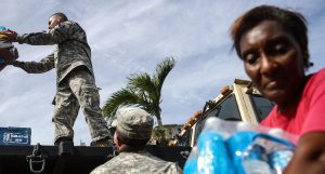 U.S. Army soldiers pass out water, provided by FEMA, to residents in a neighborhood without grid electricity or running water in San Isidro, Puerto Rico, on Oct. 17, 2017.