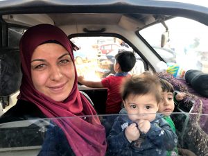 Hala, a Syrian refugee, cradles her children in the car ahead of her journey back to Syria.