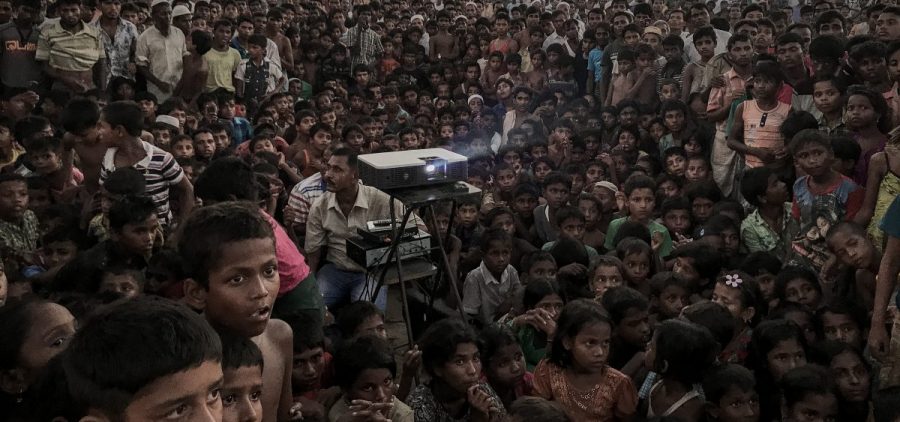 Rohingya refugees watch a film about health and sanitation in a camp in Bangladesh.