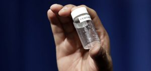 A reporter holds up an example of the amount of fentanyl that can be deadly